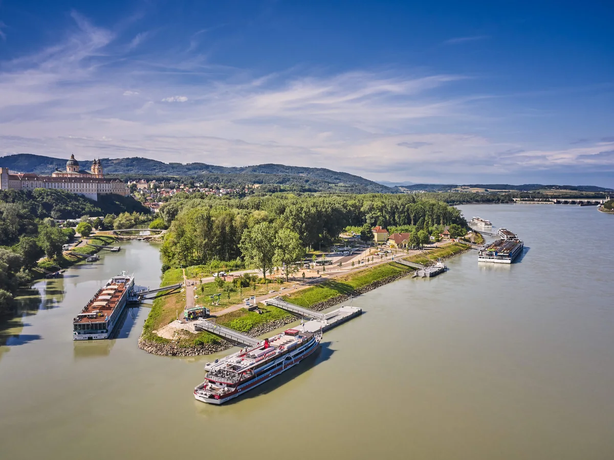 River cruise ships at Melk landing stages below Melk Abbey on the Danube