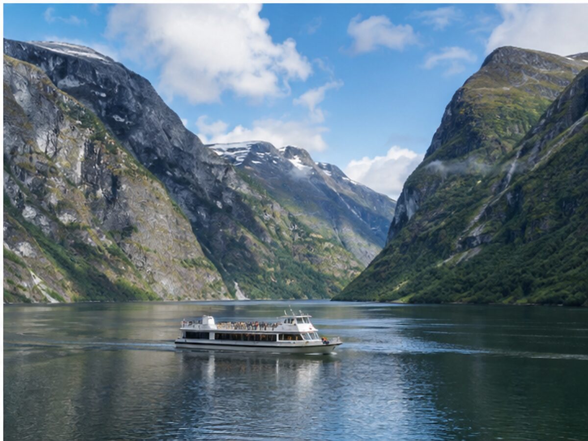 Small low-emission passenger vessel sailing through pristine Nærøyfjord
