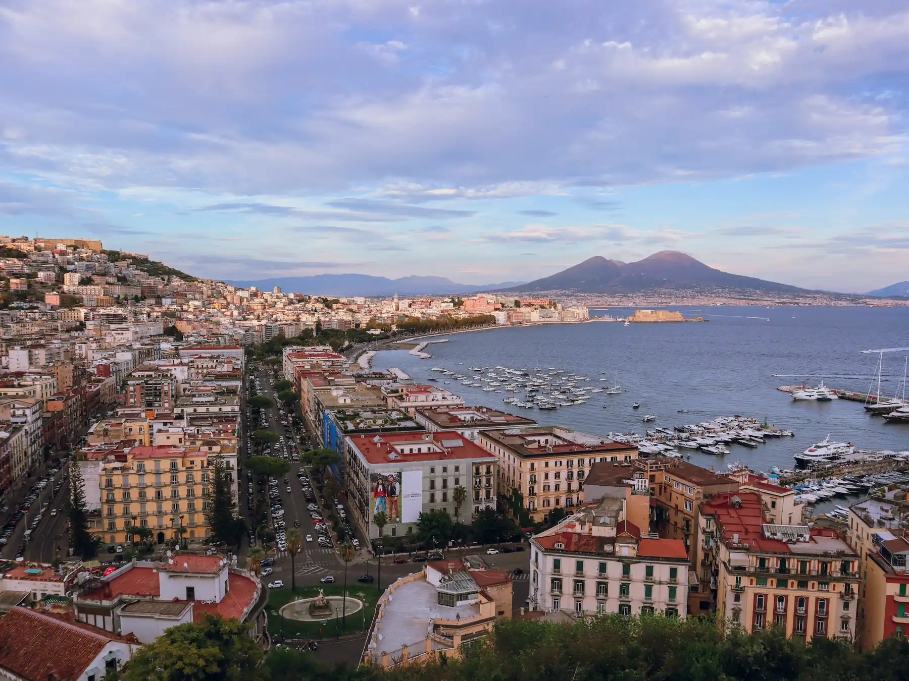 Panoramic view of the Naples waterfront and Bay of Naples with Mount Vesuvius in the distance.