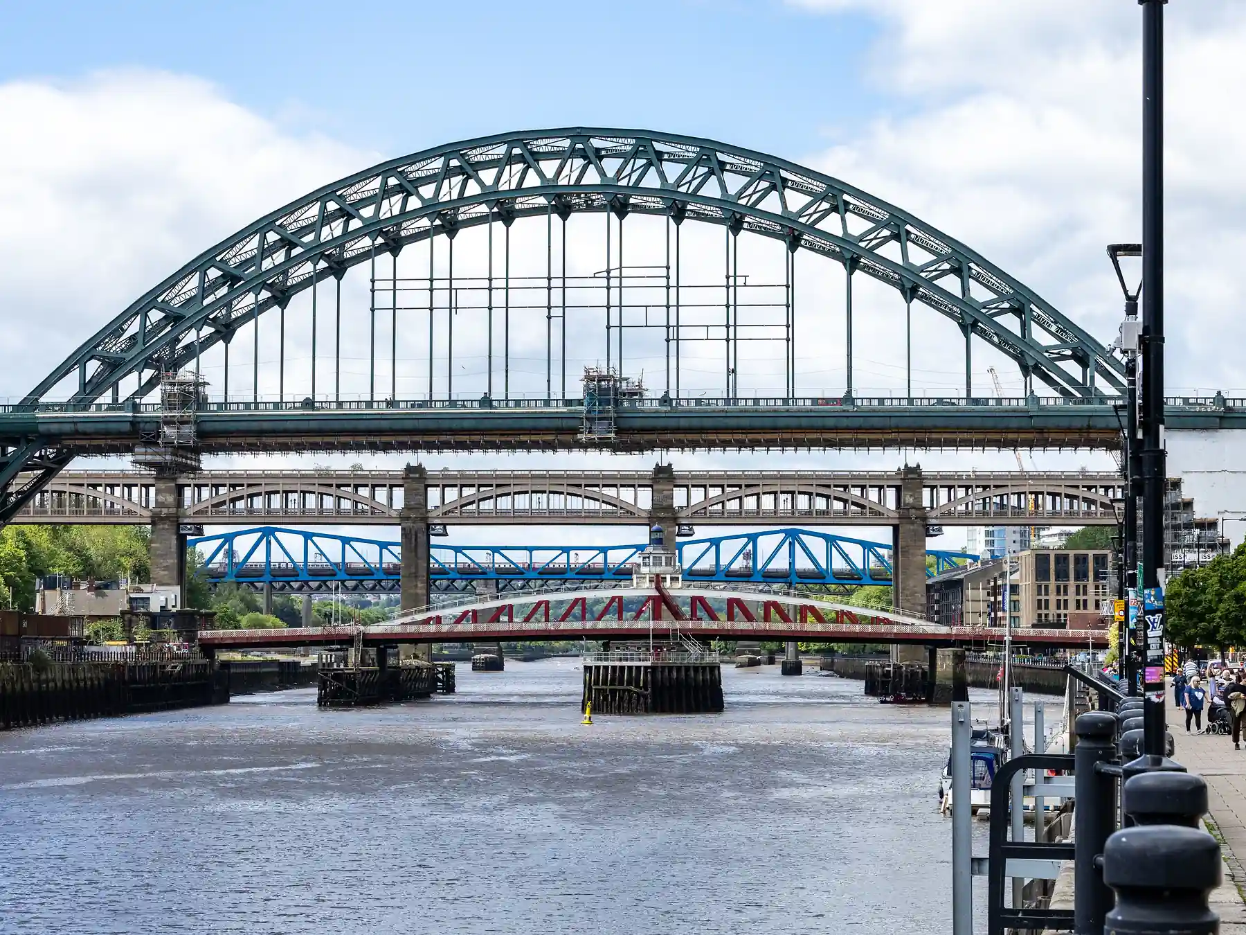 Tyne Bridge spanning the River Tyne beside Newcastle's waterfront on a sunny day.