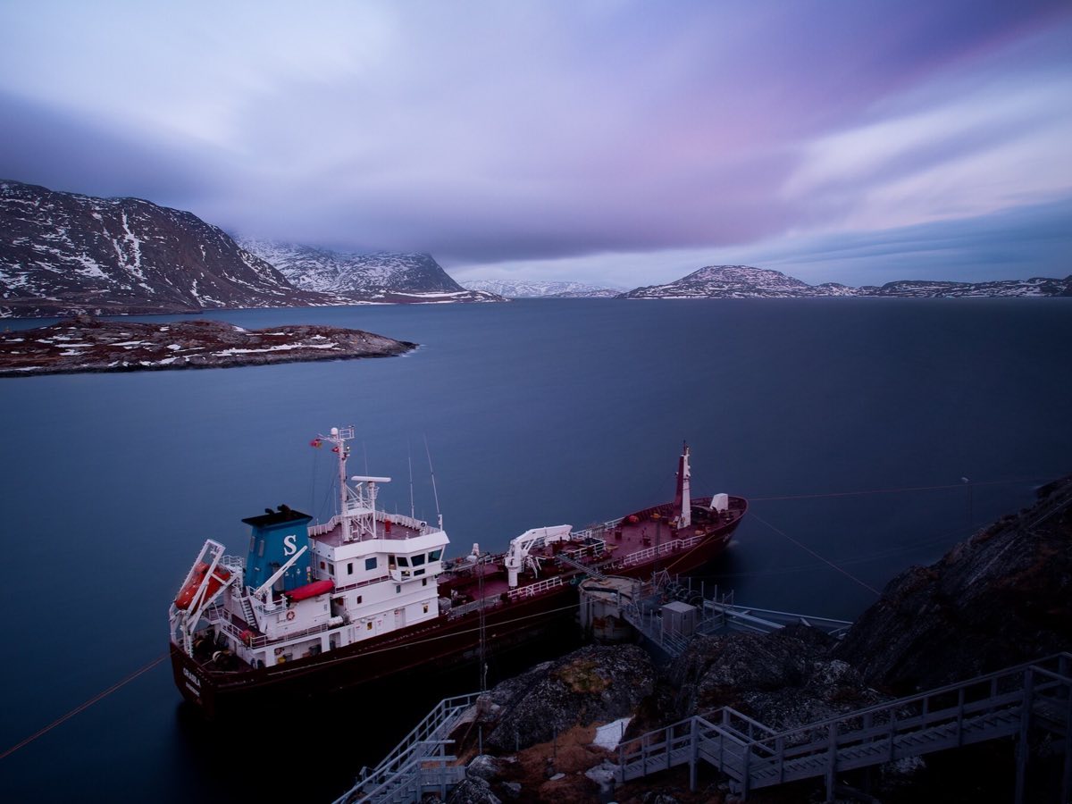 Ship moored below rocky slopes in the fjord at Nuuk