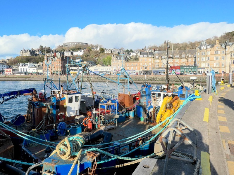 Fishing boats moored in Oban Harbour with the town waterfront behind