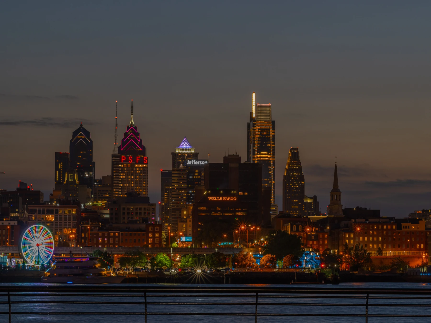 Philadelphia skyline illuminated at night above the riverfront