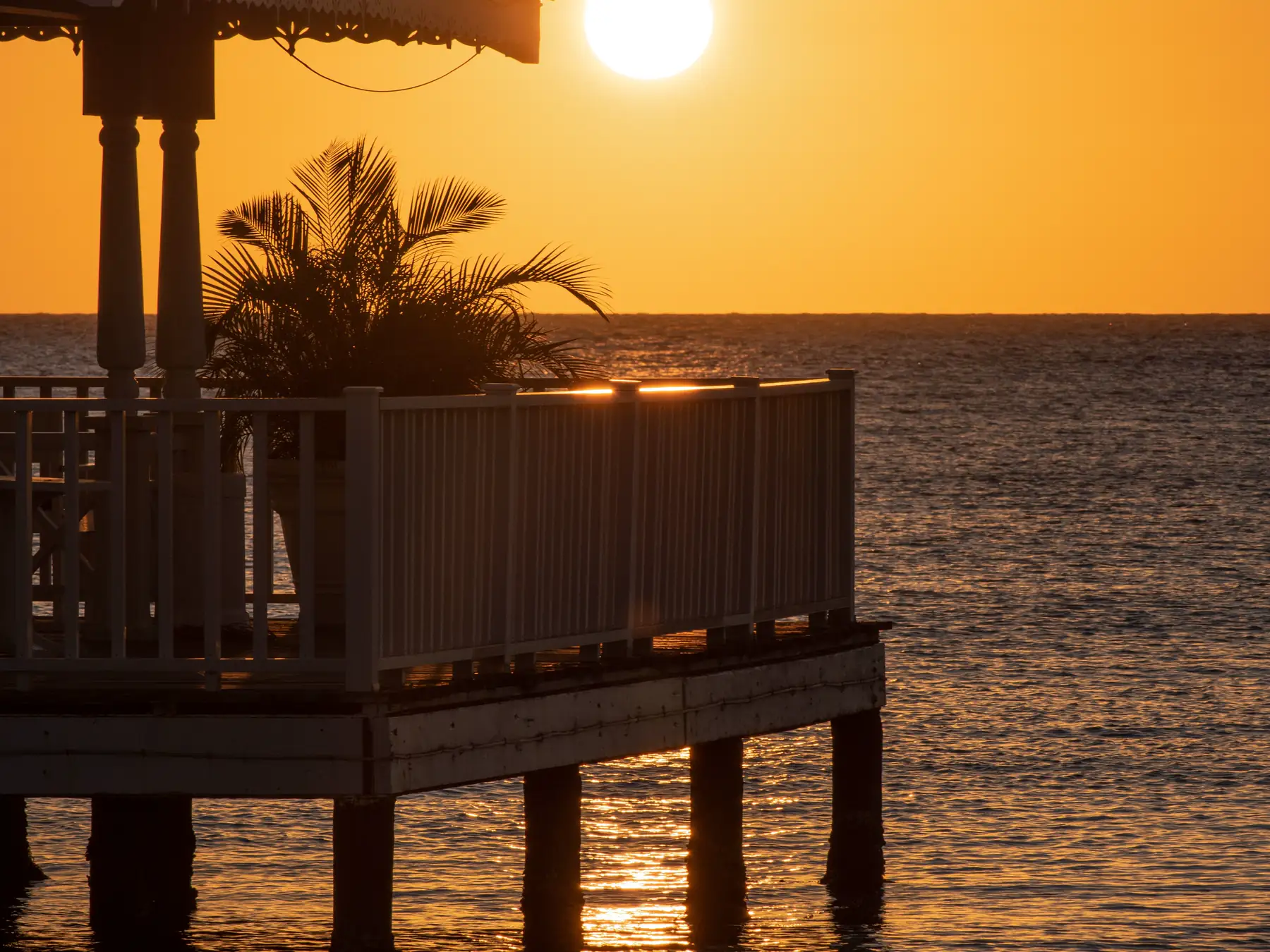 Wooden pier extending into the Caribbean Sea at sunset in La Romana
