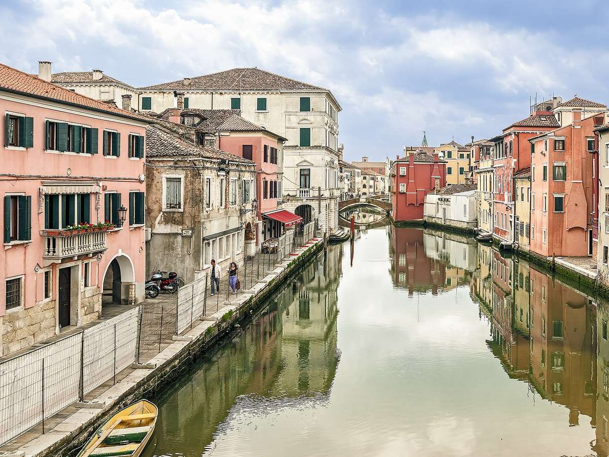 Boats and colorful buildings along a canal in Chioggia