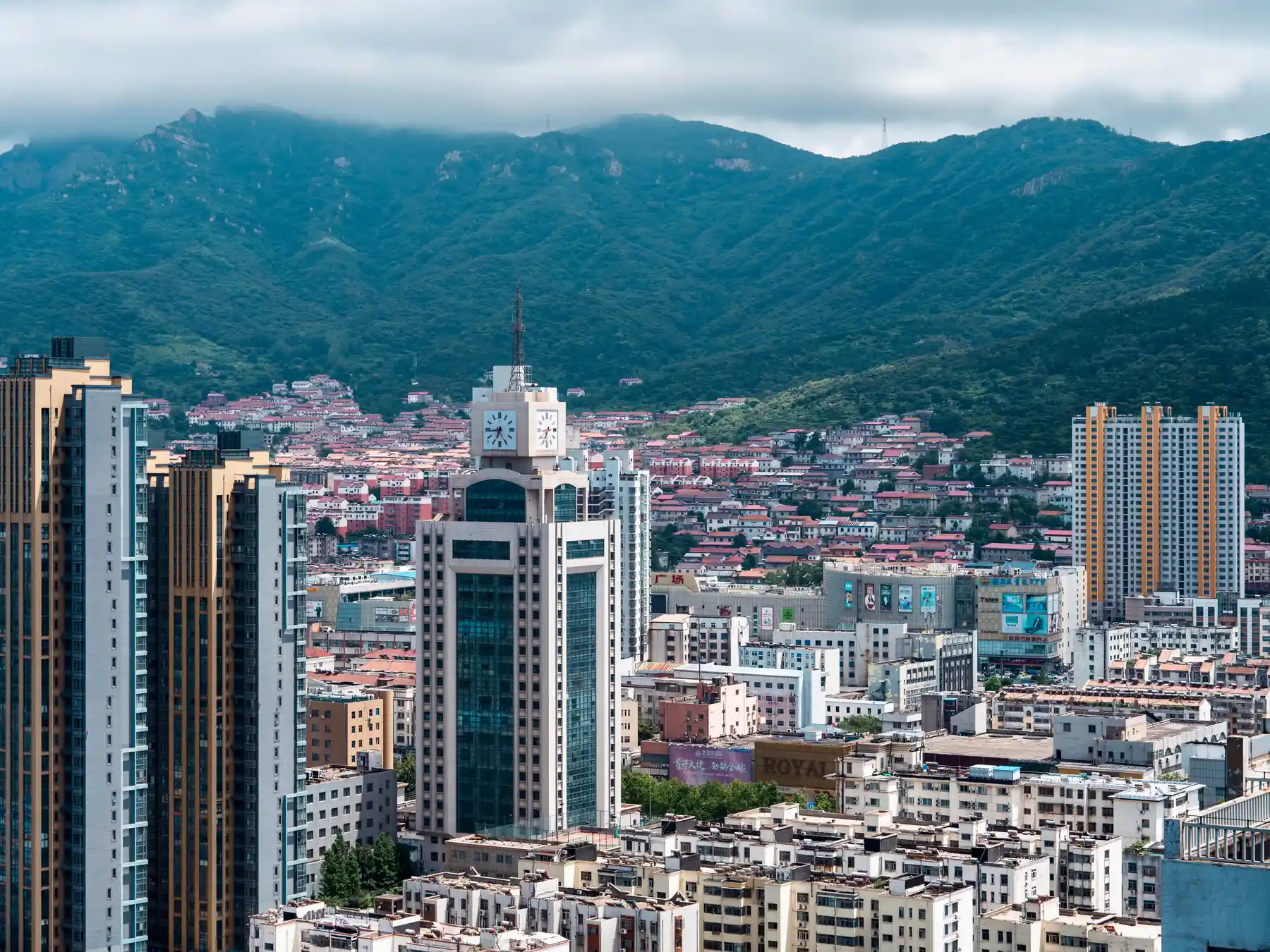 Aerial view of Qingdao skyline with green hills beyond the city