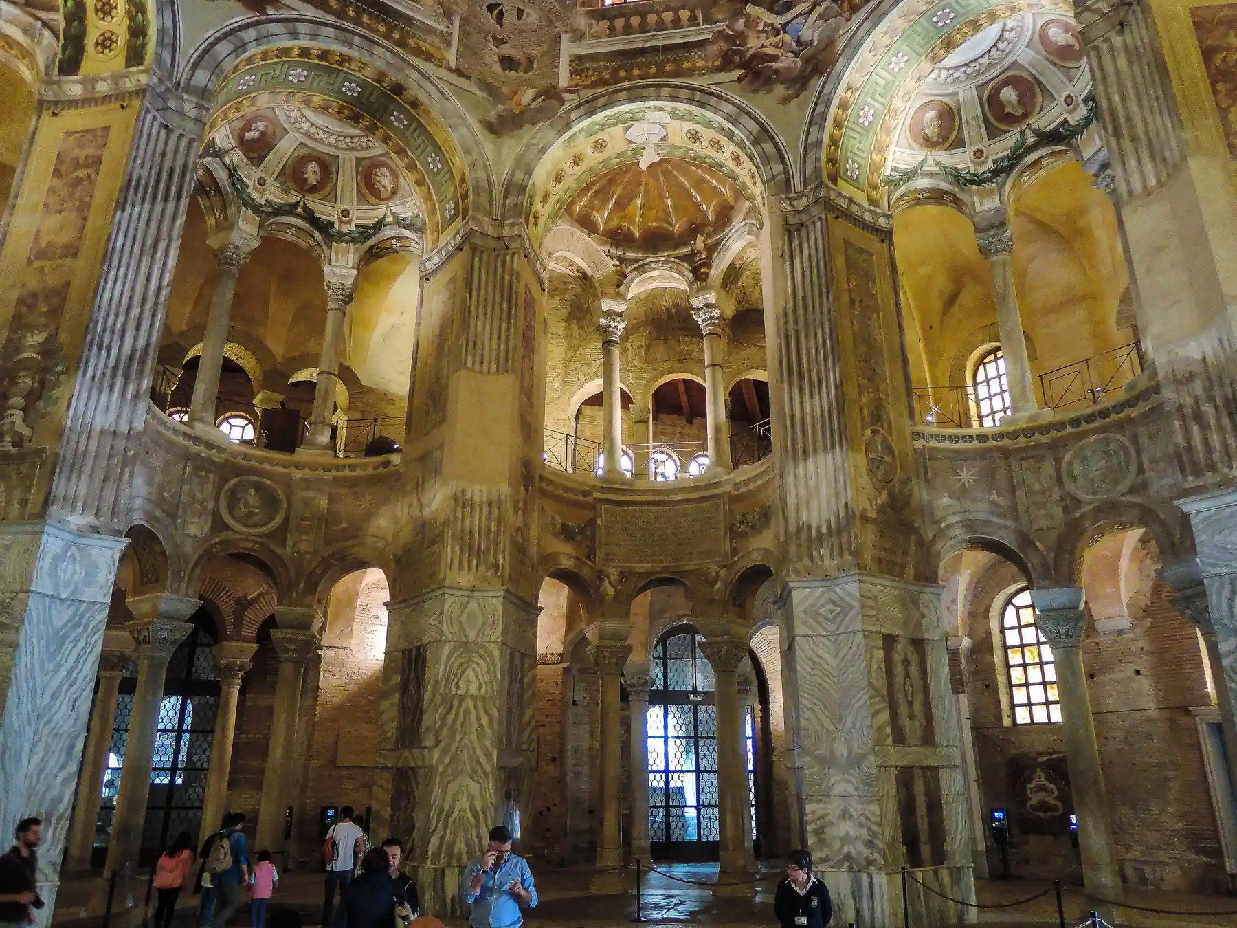 Historic columns, arches, and mosaics inside the Basilica of San Vitale in Ravenna.