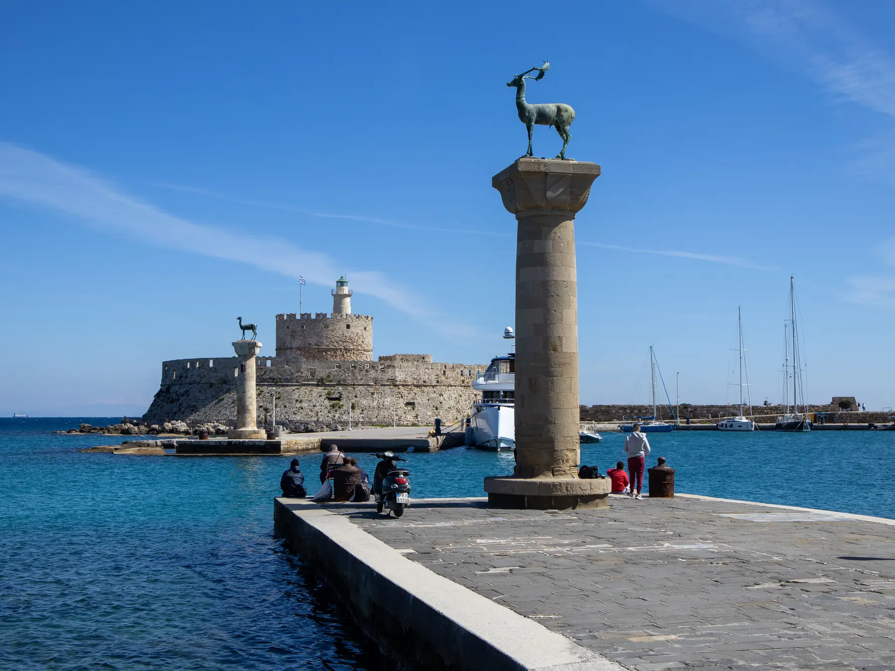 Mandraki Harbor in Rhodes with medieval fort and deer statues