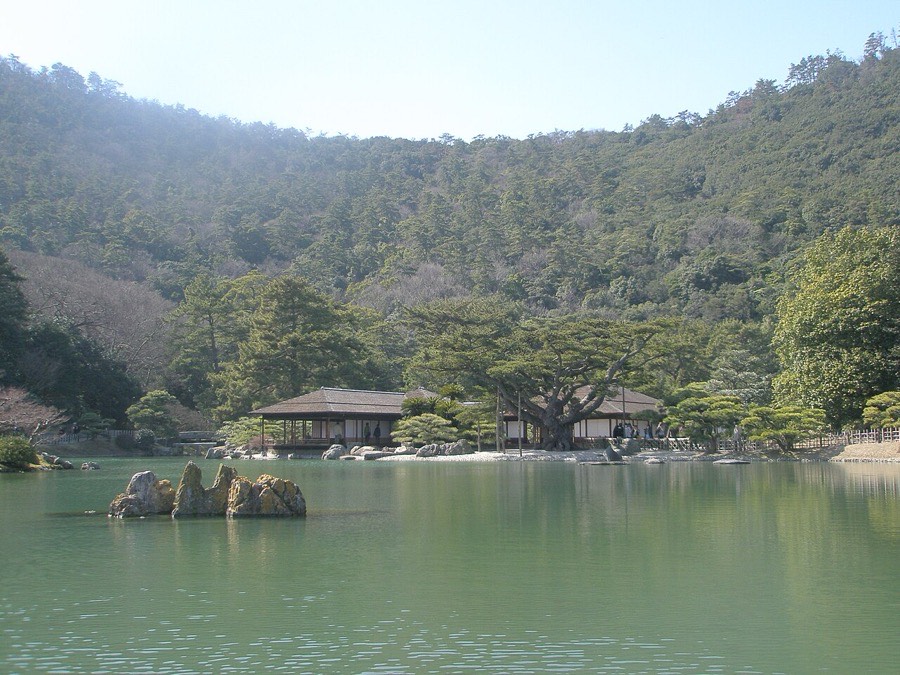 Traditional pavilion beside a green pond in Ritsurin Garden, Takamatsu