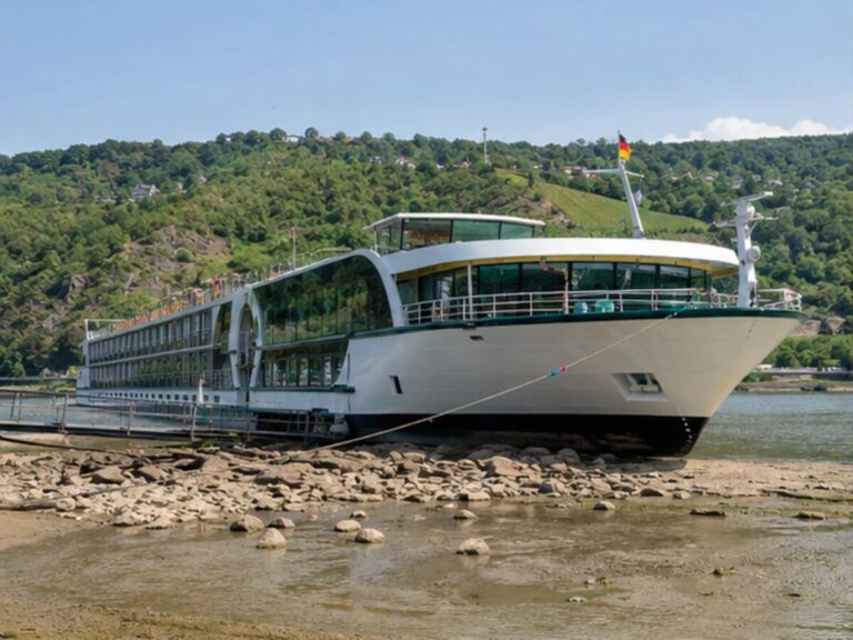 River cruise ship moored beside a visibly low river
