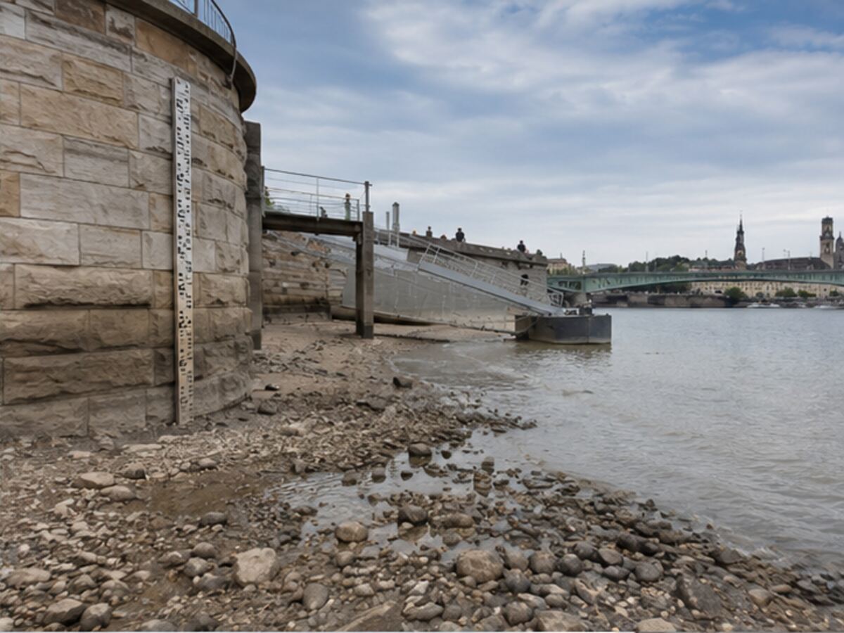 An exposed riverbank and water-level gauge showing low-water conditions