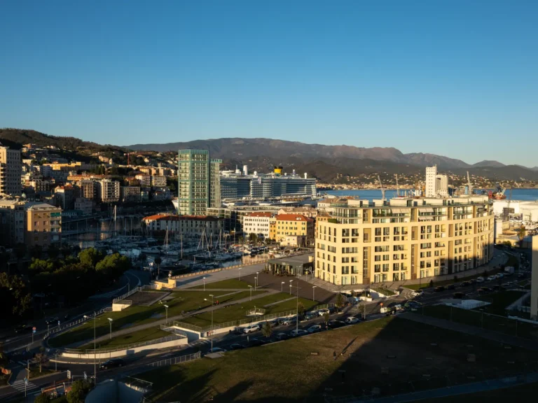 Savona waterfront and cruise port with a Costa ship docked beside the city.