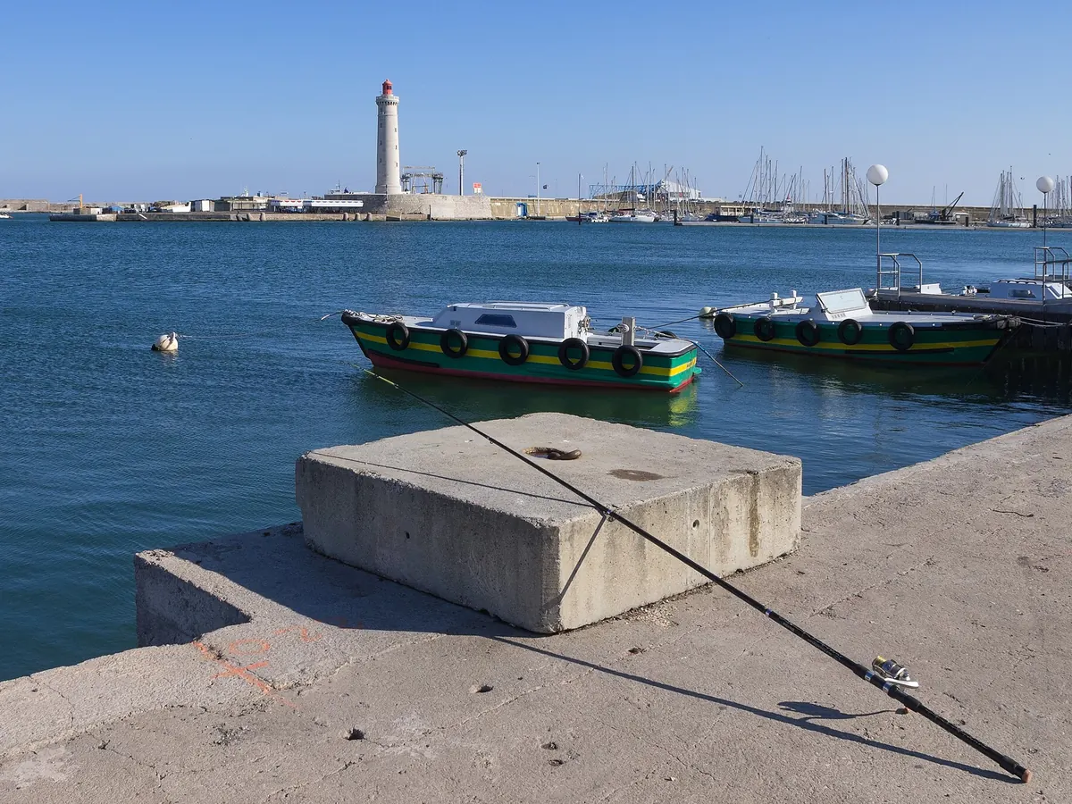 Fishing boats and the Saint-Louis lighthouse at Sète harbour