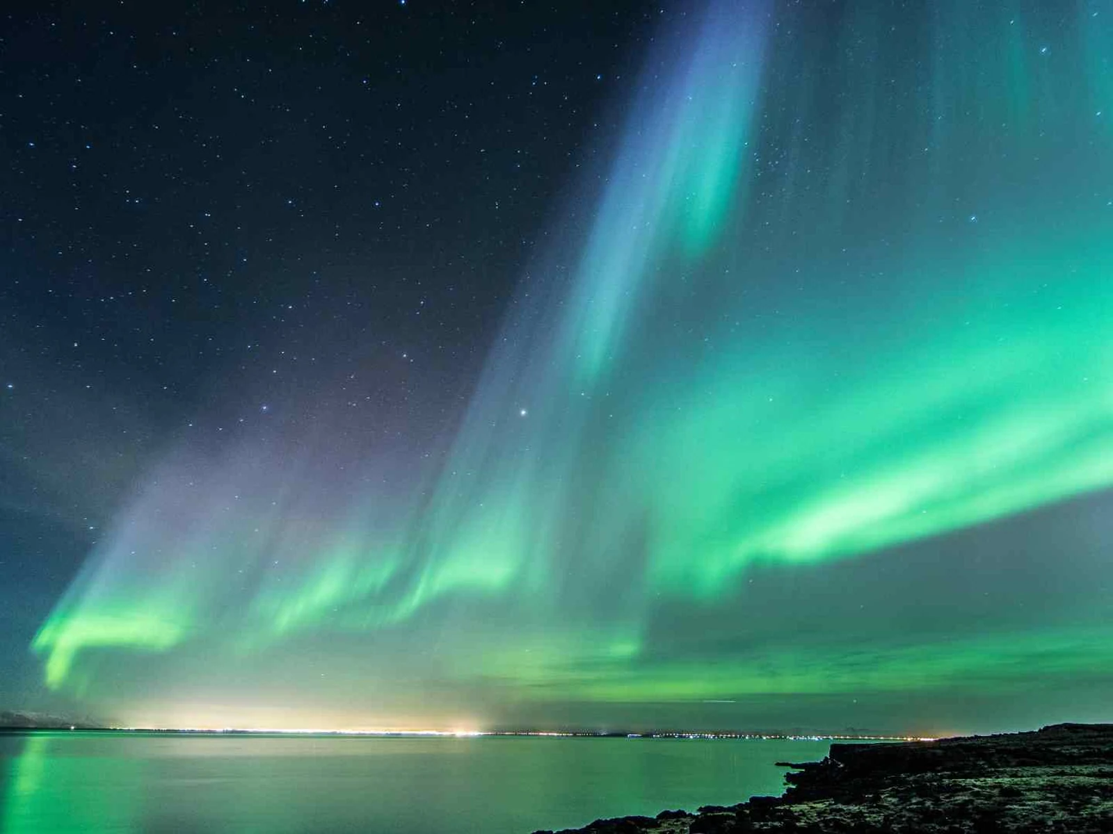 Northern lights glowing above the Icelandic coast