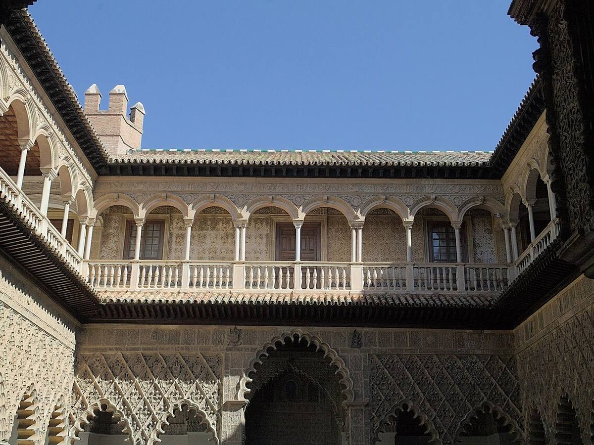 Ornate arches and upper gallery in the Courtyard of the Maidens at Seville's Real Alcázar