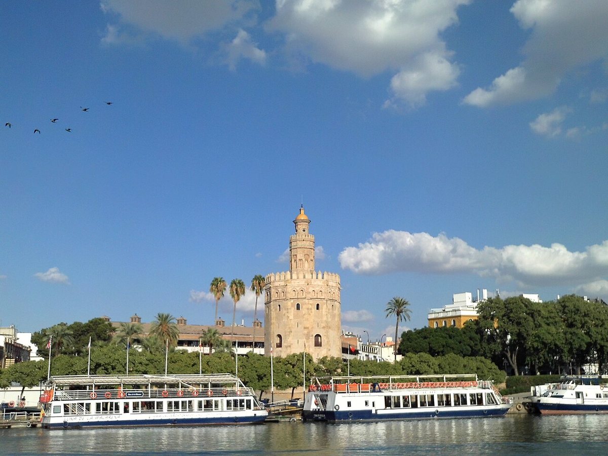 Torre del Oro behind sightseeing boats on the Guadalquivir in Seville, Spain