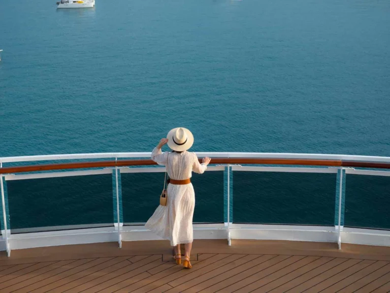 Traveler looking over the sea from a cruise ship railing