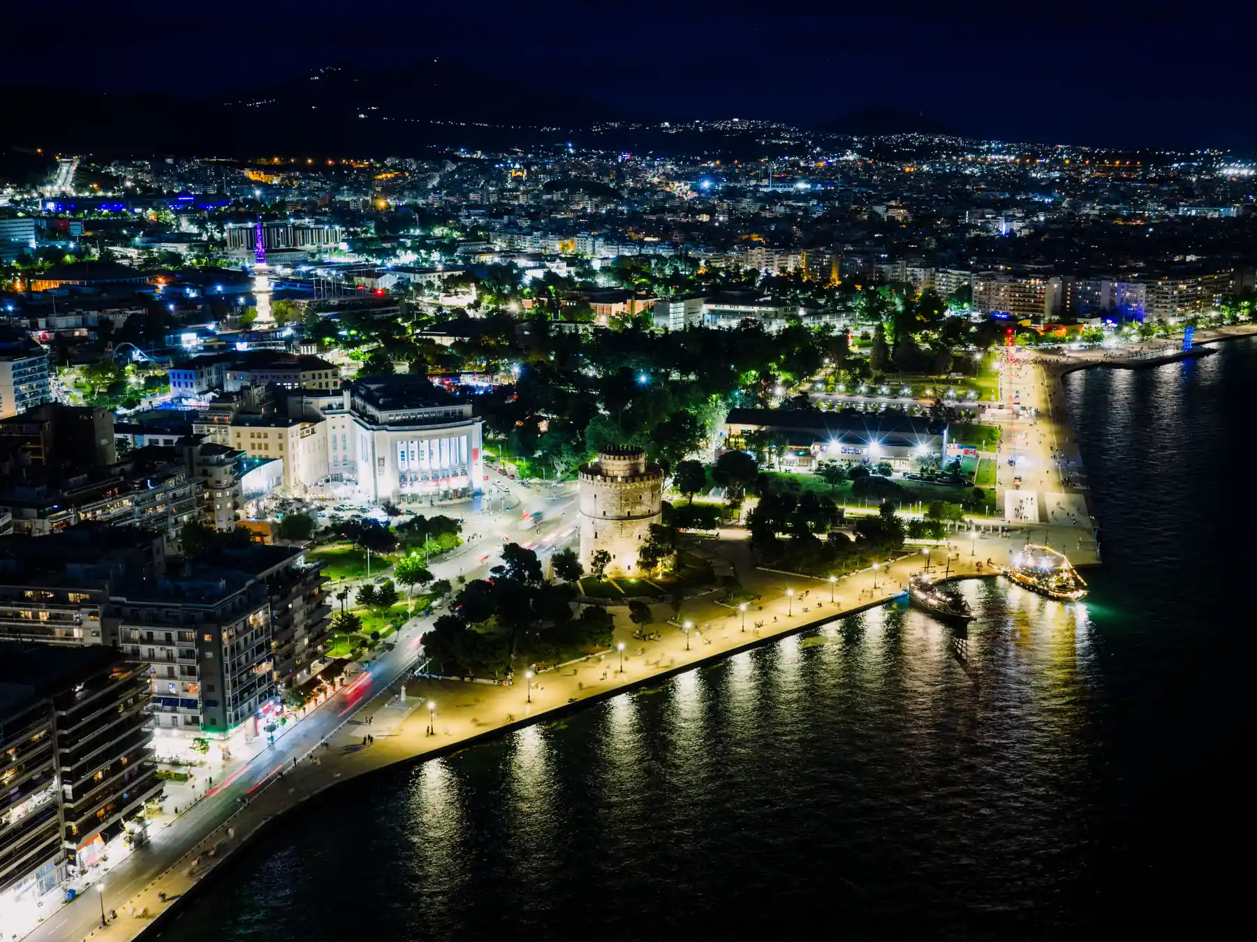 Aerial night view of Thessaloniki waterfront and illuminated White Tower