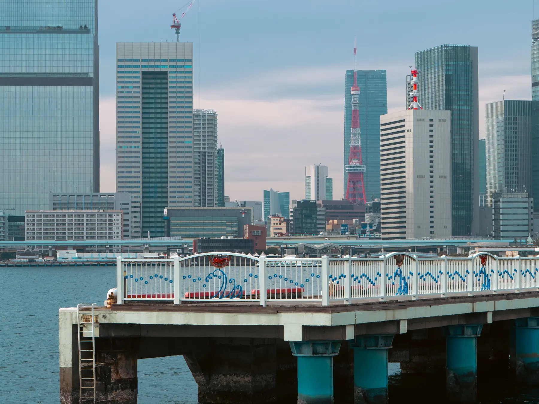 Tokyo's skyline and waterfront viewed across Odaiba Pier.