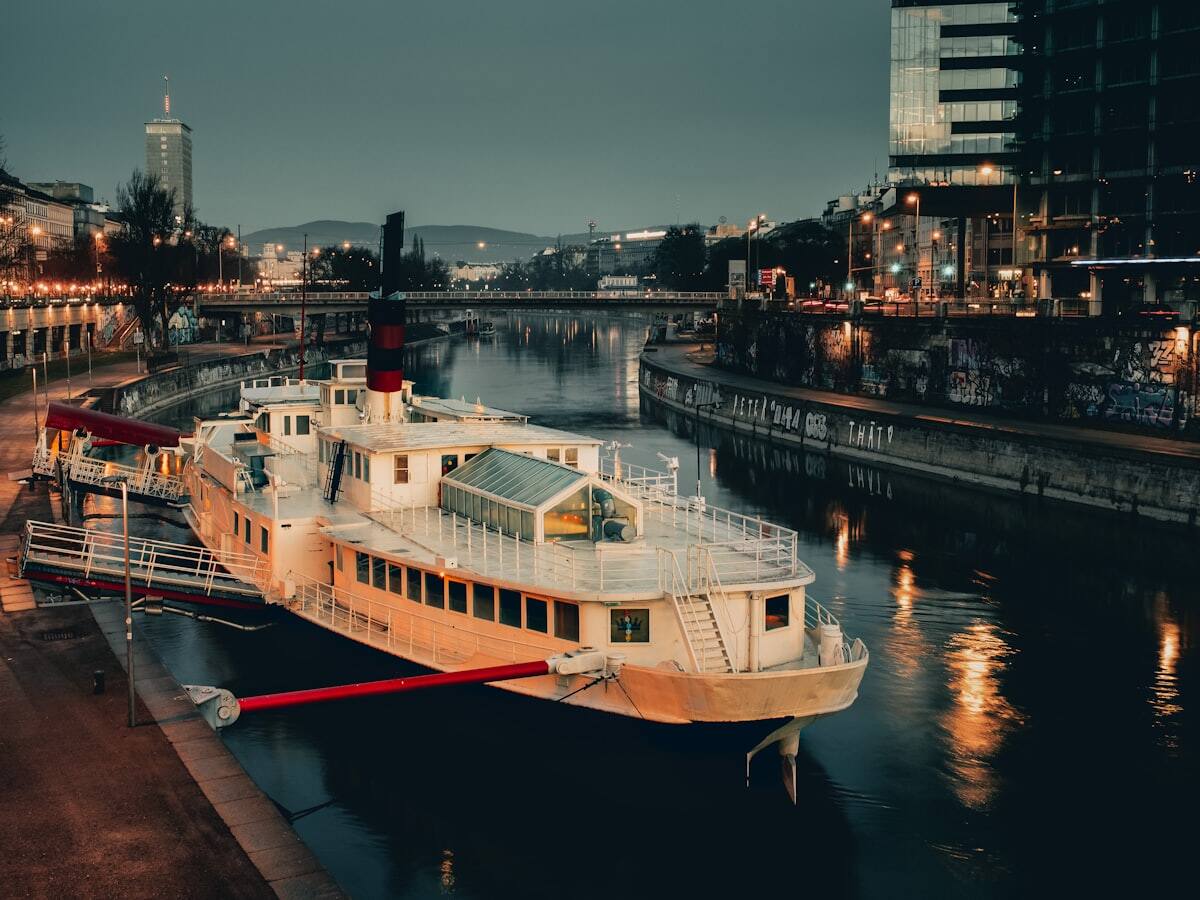 Riverboat docked along Vienna's illuminated Danube Canal at night