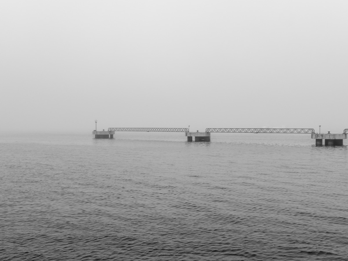 Harbor pier fading into morning fog at the Port of Vigo