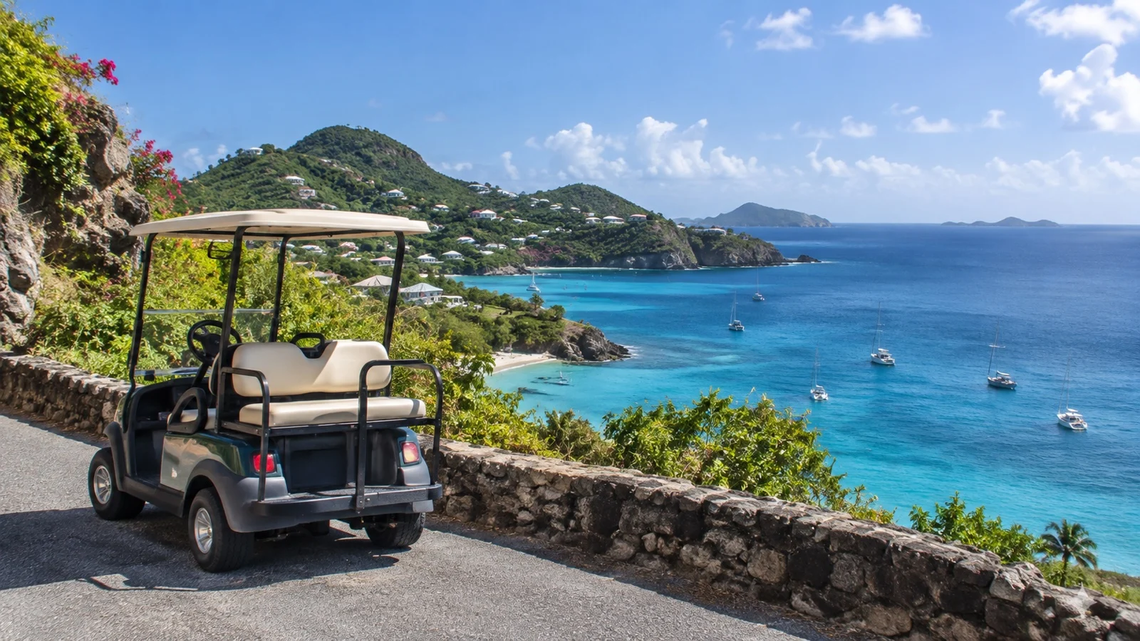 Golf cart on a tropical island road overlooking the sea.