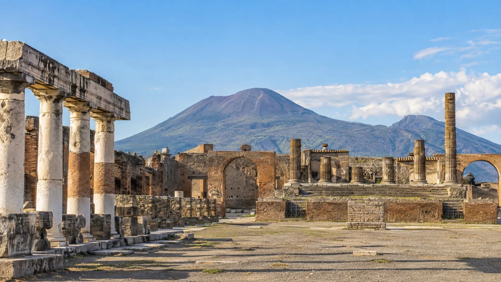 Pompeii Roman forum ruins with Mount Vesuvius behind.