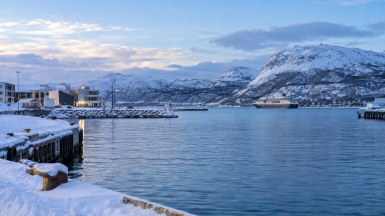Snow-covered Alta harbor and distant Arctic mountains in winter