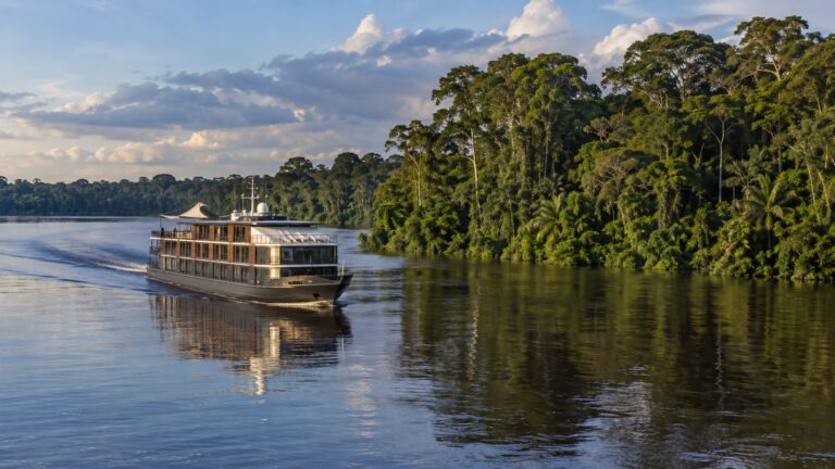 Small Amazon expedition ship sailing upriver