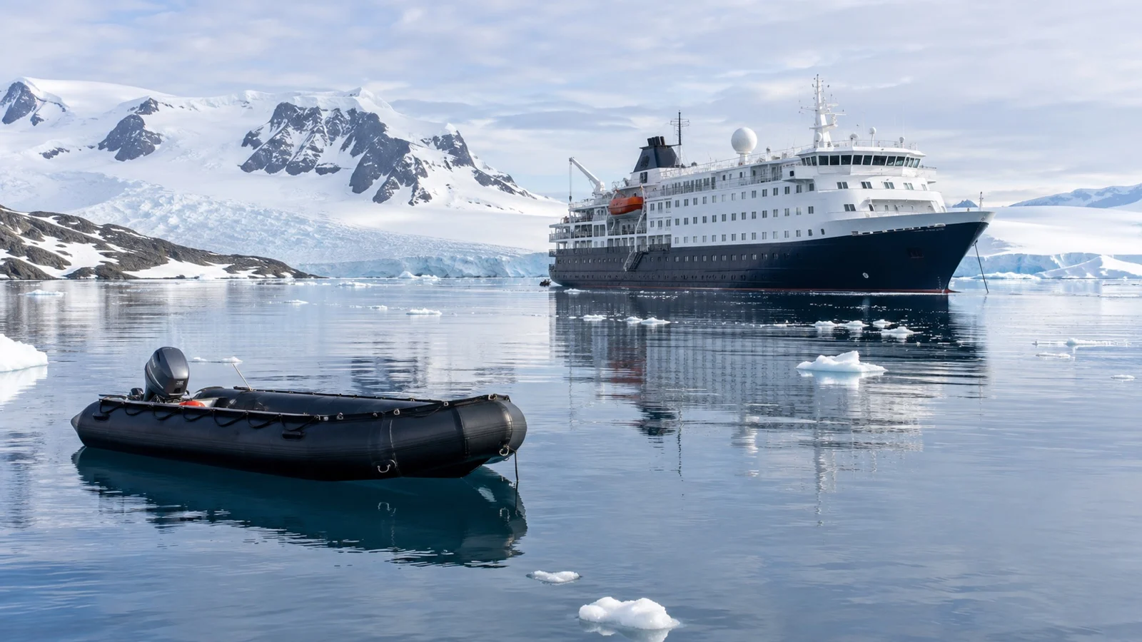 Expedition ship and empty Zodiac near Antarctic landing