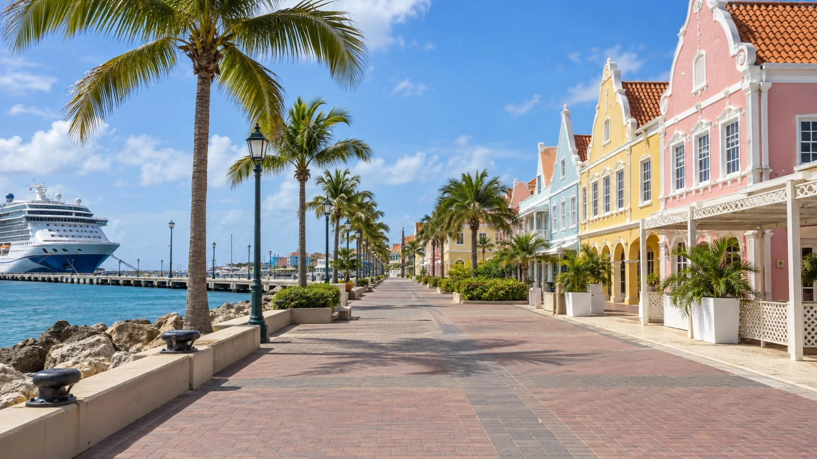 Empty palm-lined waterfront walkway from the Aruba cruise pier toward Oranjestad