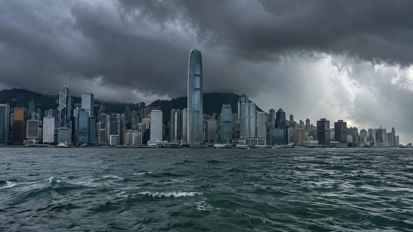 Hong Kong Victoria Harbour under dark typhoon-season clouds