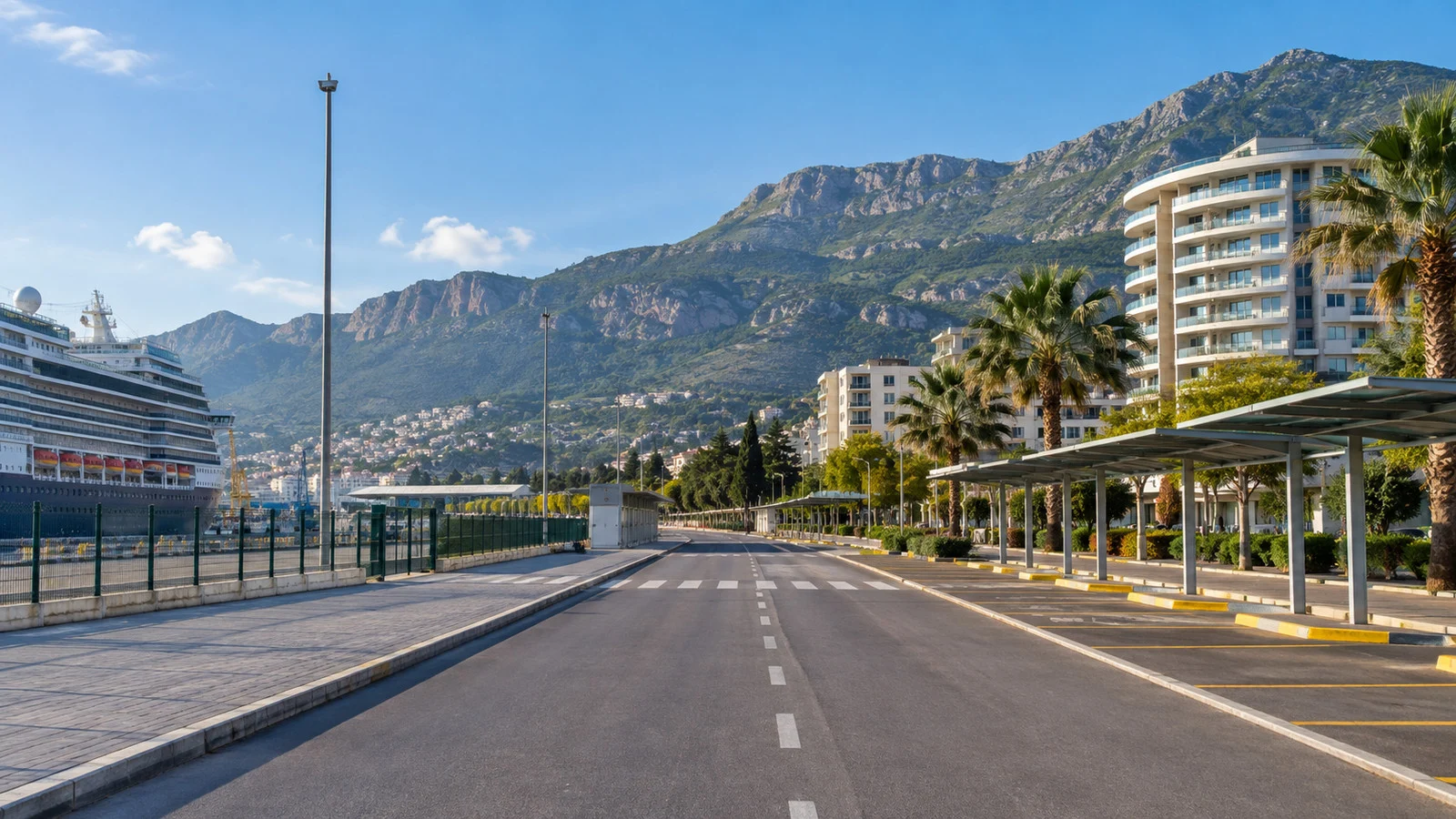 an empty road and taxi stand between Bar's port and modern town with the mountains behind