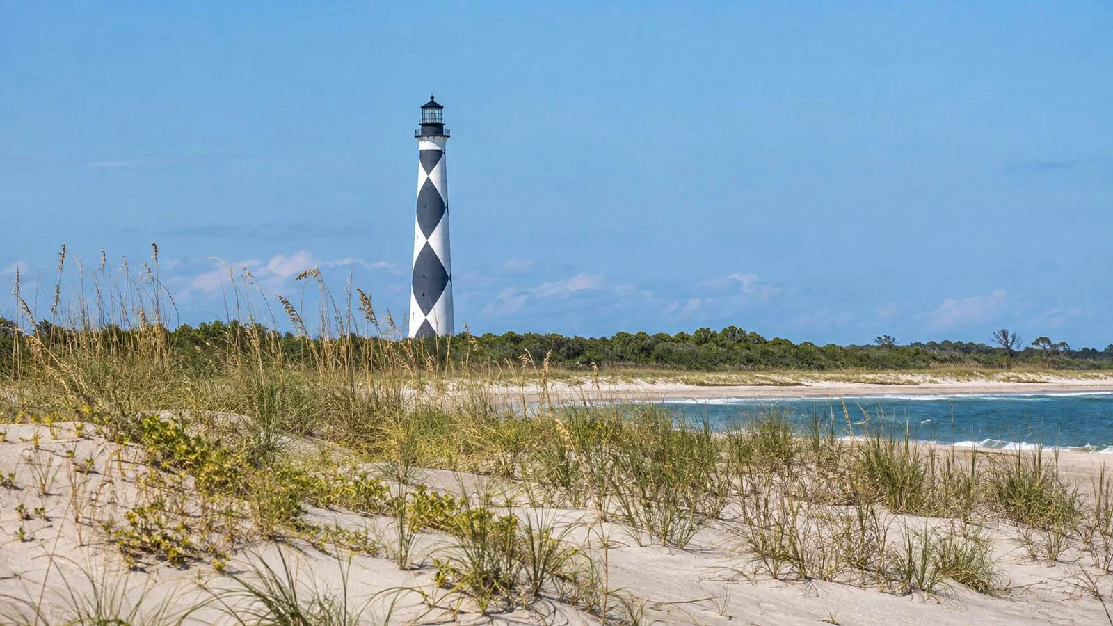 Cape Lookout Lighthouse North Carolina black-and-white diamond pattern rising beyond sandy barrier island dunes, no people