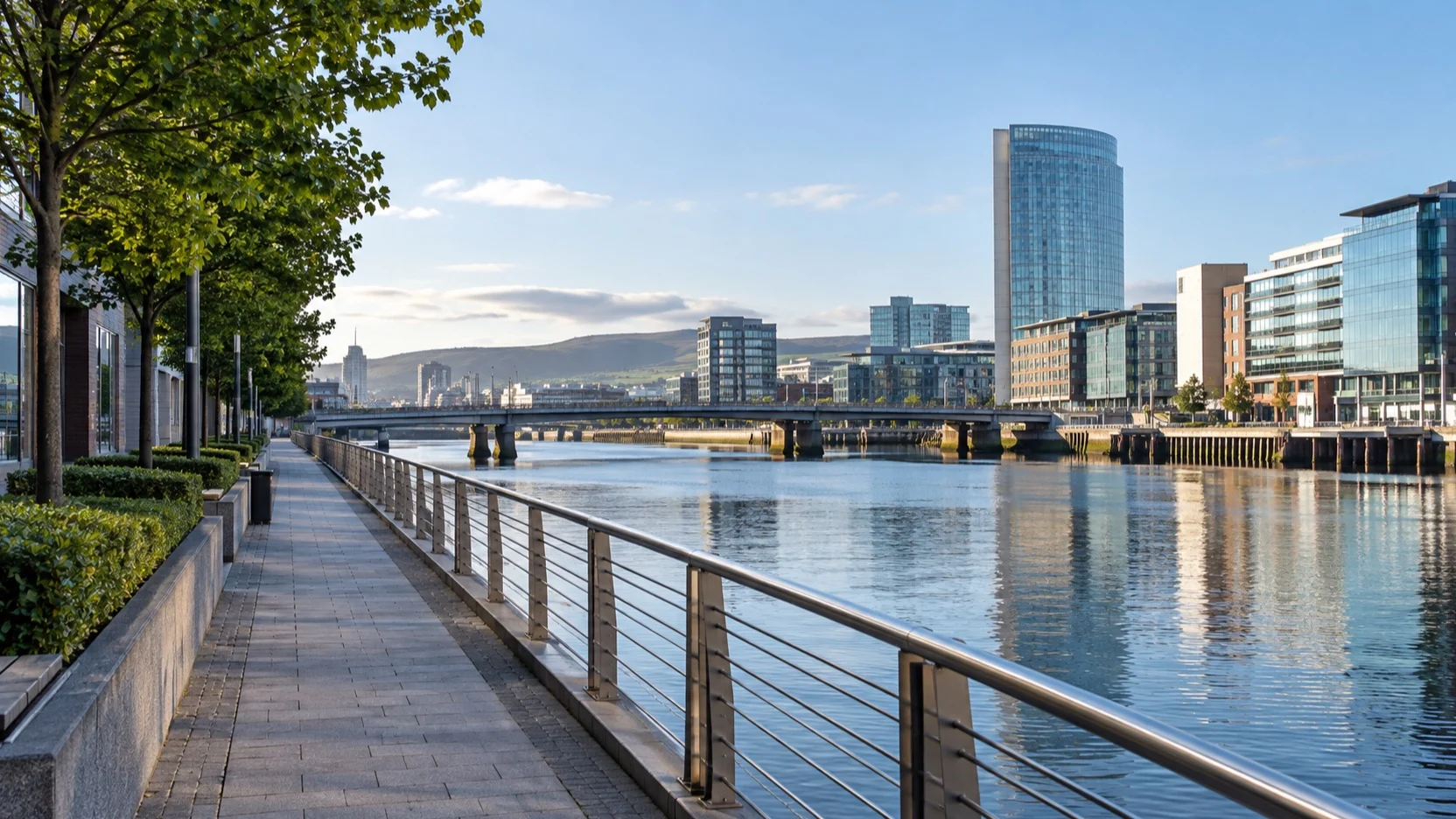 An empty walkway beside Belfast's River Lagan and city buildings