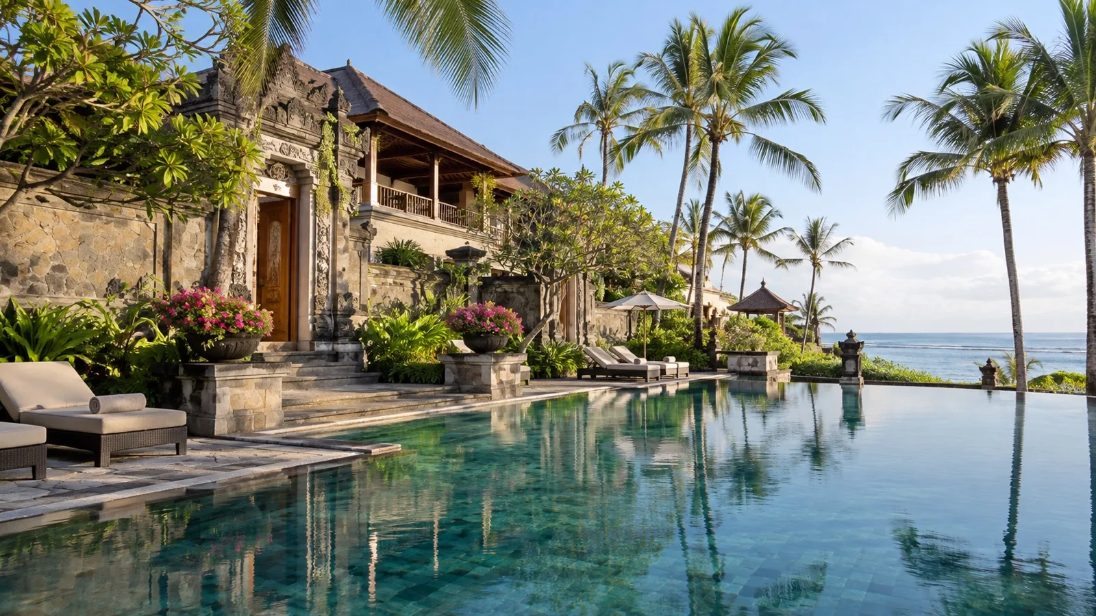 Elegant Nusa Dua resort hotel in Bali with Balinese stone architecture, palm trees and a quiet pool