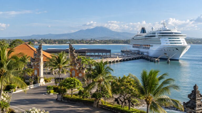 Benoa cruise terminal in Bali with a white cruise ship docked in the harbor, tropical palms and distant Balinese coast