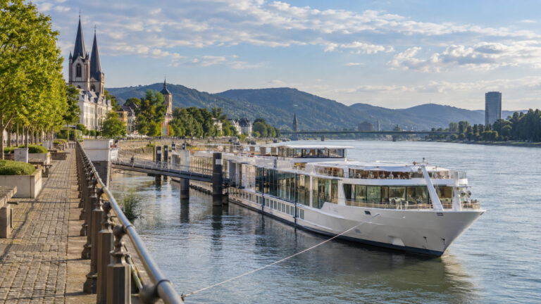 a river cruise ship moored on the Rhine at Bonn with the city waterfront and river promenade