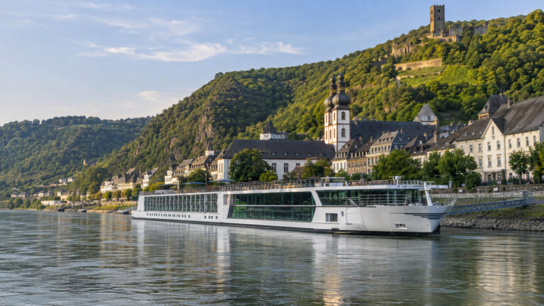 River cruise vessel moored on Boppard Rhine Germany waterfront with green river valley and town behind, no people