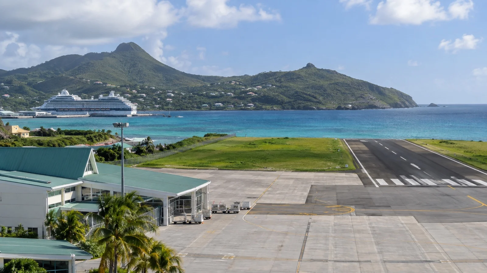 Empty small Caribbean airport runway and terminal near a cruise harbor
