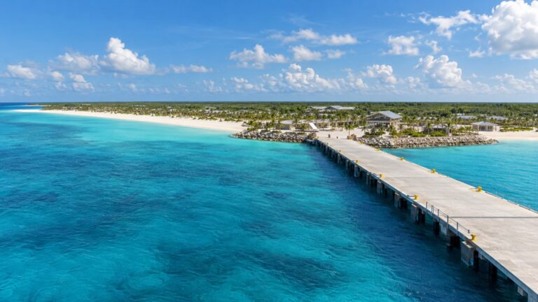 Celebration Key pier beside white sand and turquoise Bahamian water