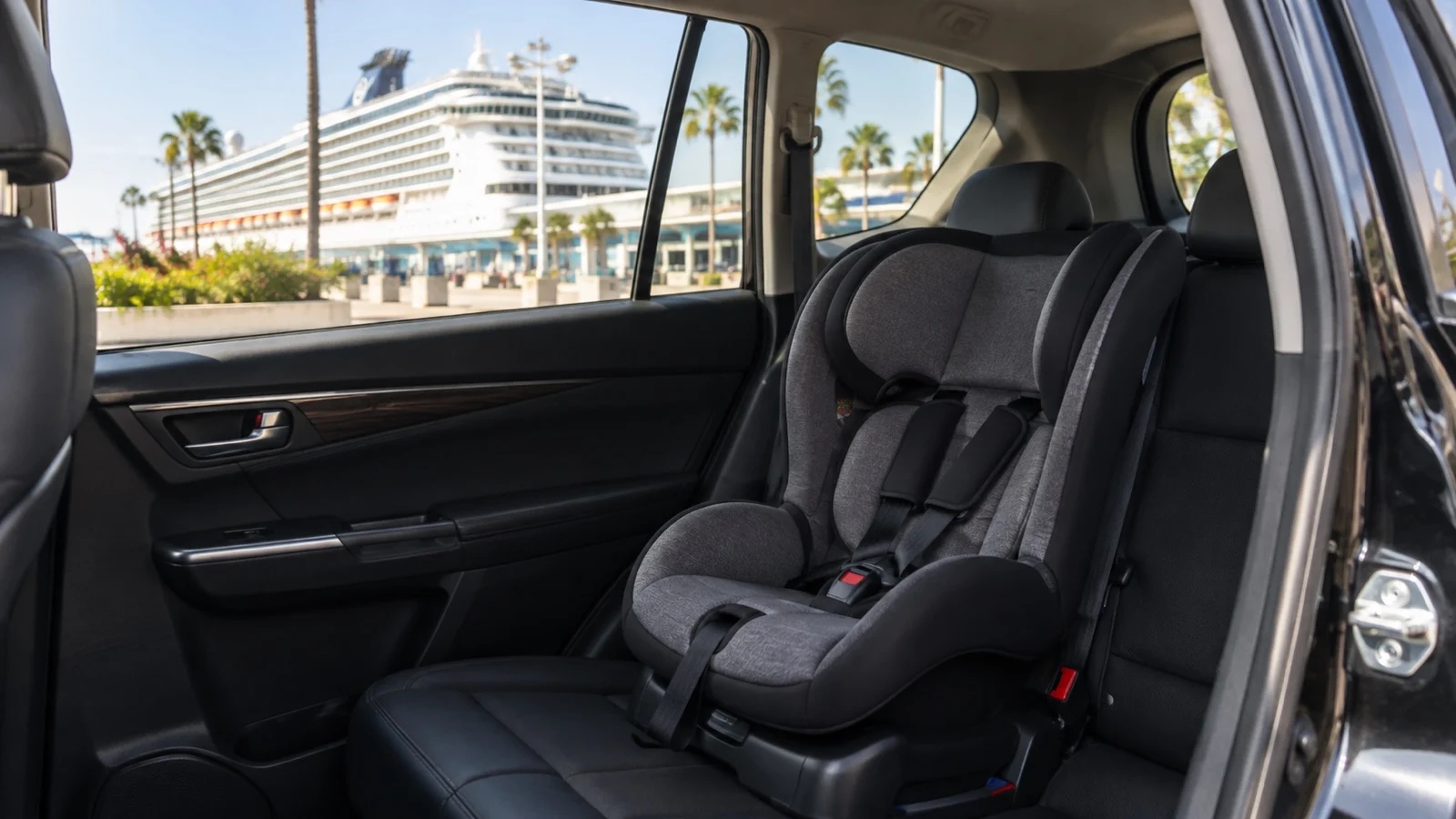 Empty child car seat installed in back of car beside cruise terminal
