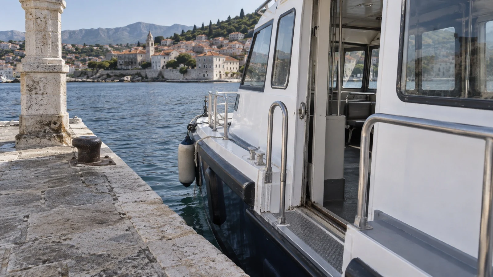 Small cruise tender boat beside pier showing narrow boarding threshold, no people