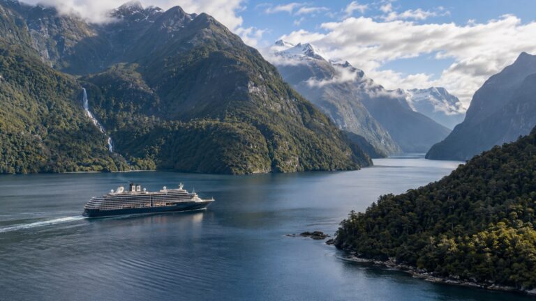 Cruise ship amid forested mountains in Doubtful Sound