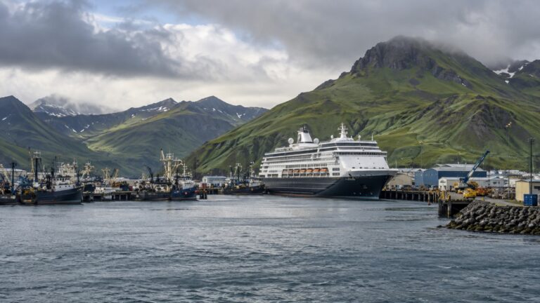 Cruise ship at a working Dutch Harbor berth below green Aleutian hills