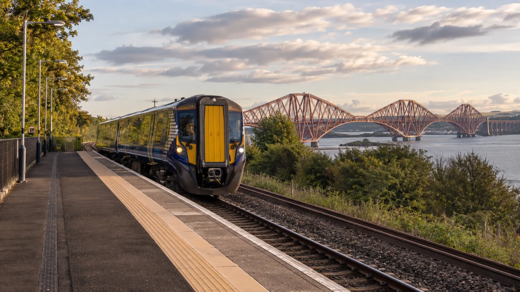 A train beside an empty platform near South Queensferry and the Forth Bridge