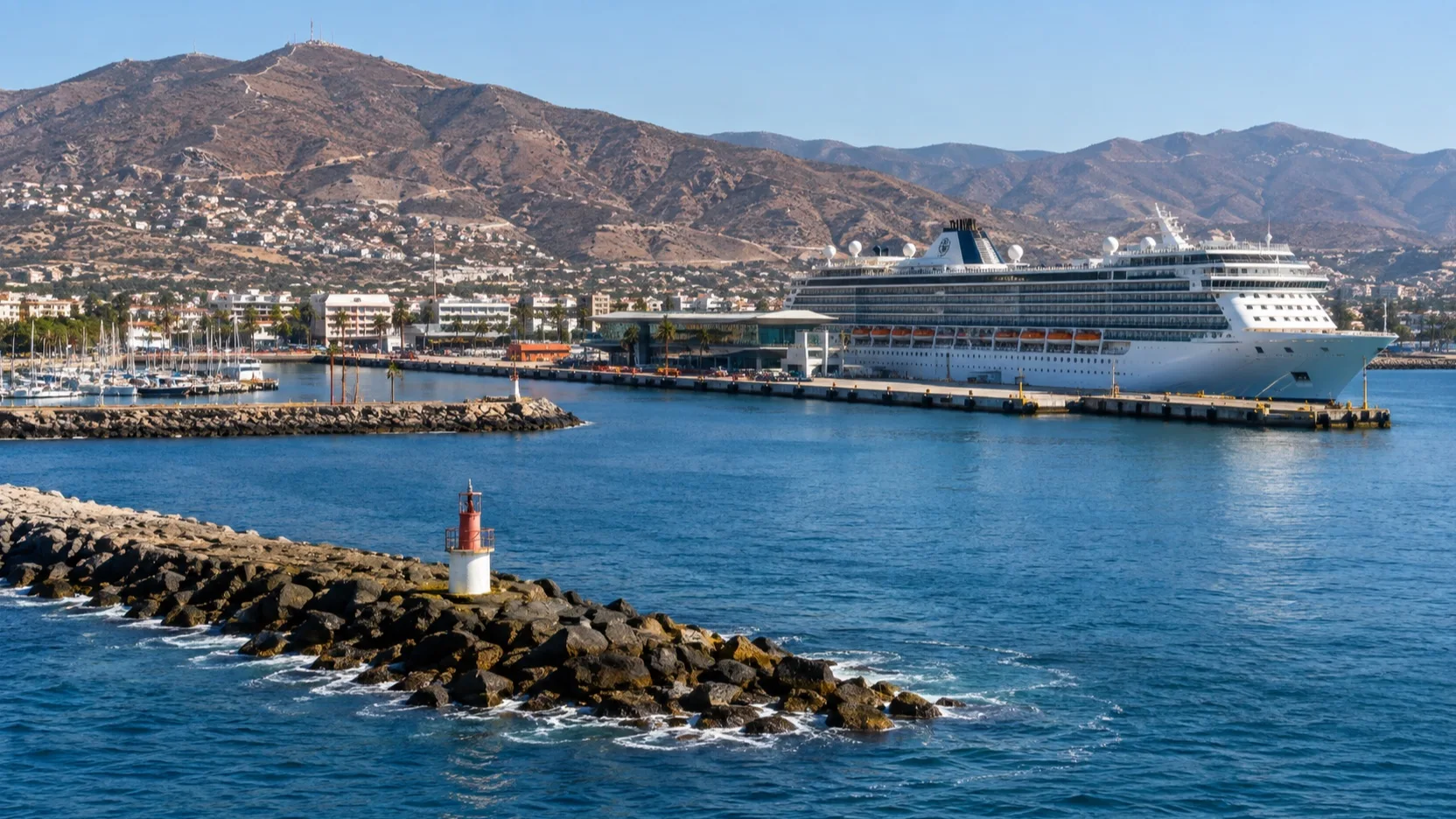 A cruise ship at Ensenada's Pacific harbor beneath Baja coastal hills