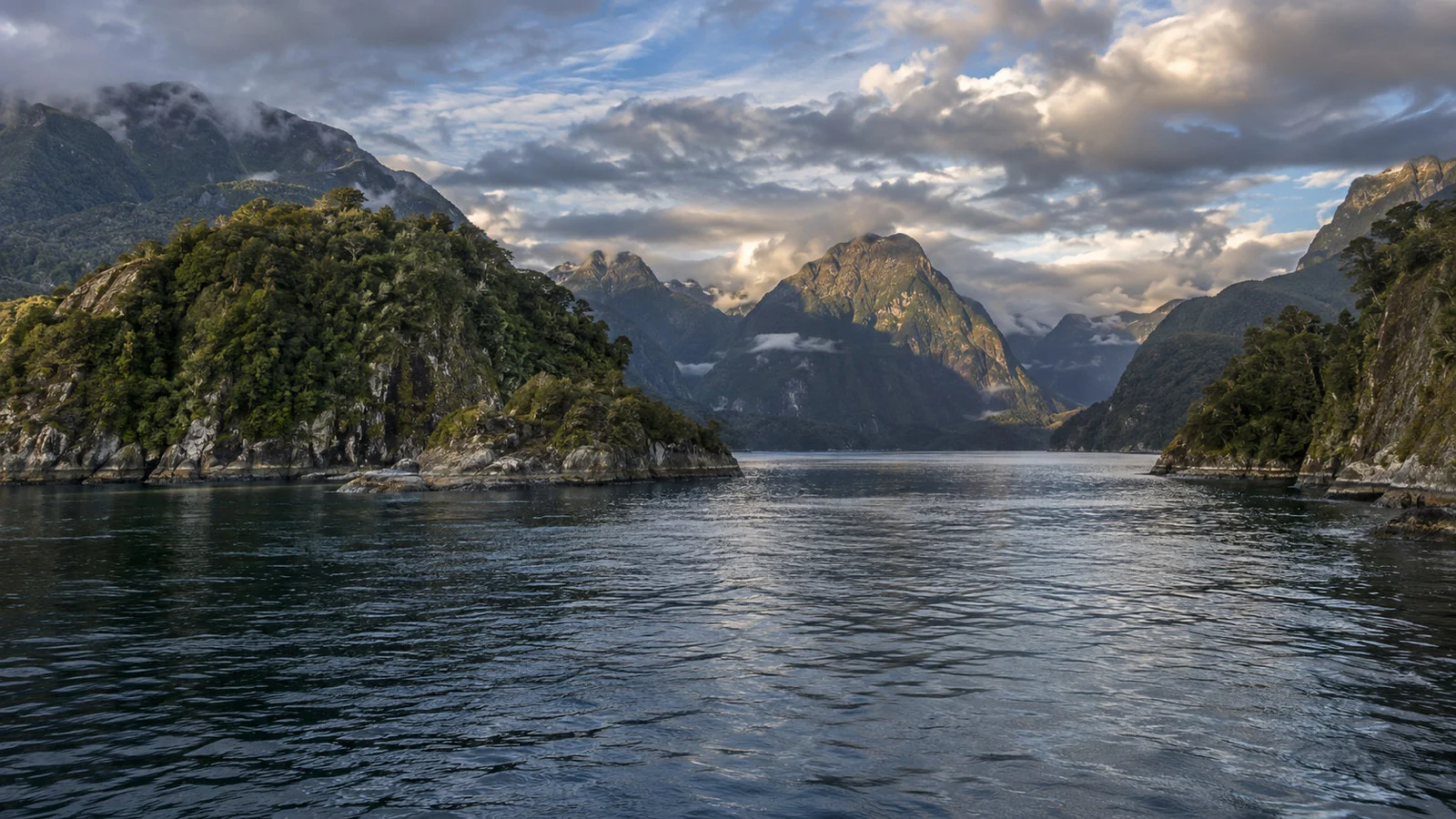 Dusky Sound Tamatea remote Fiordland New Zealand rocky forested coast and islands under dramatic sky, no people