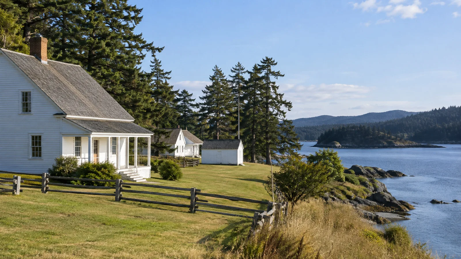 English Camp San Juan Island historic white wooden buildings beside sheltered shore and grassy grounds, no people