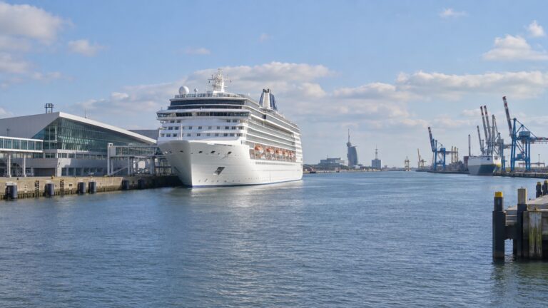 Cruise ship at Bremerhaven harbor with North Sea port cranes and waterfront buildings